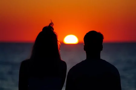 silhouette-couple-enjoying-beautiful-sunset-shore-sea